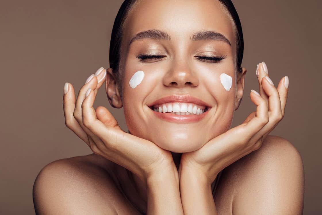 mujer aplicando crema en el rostro
