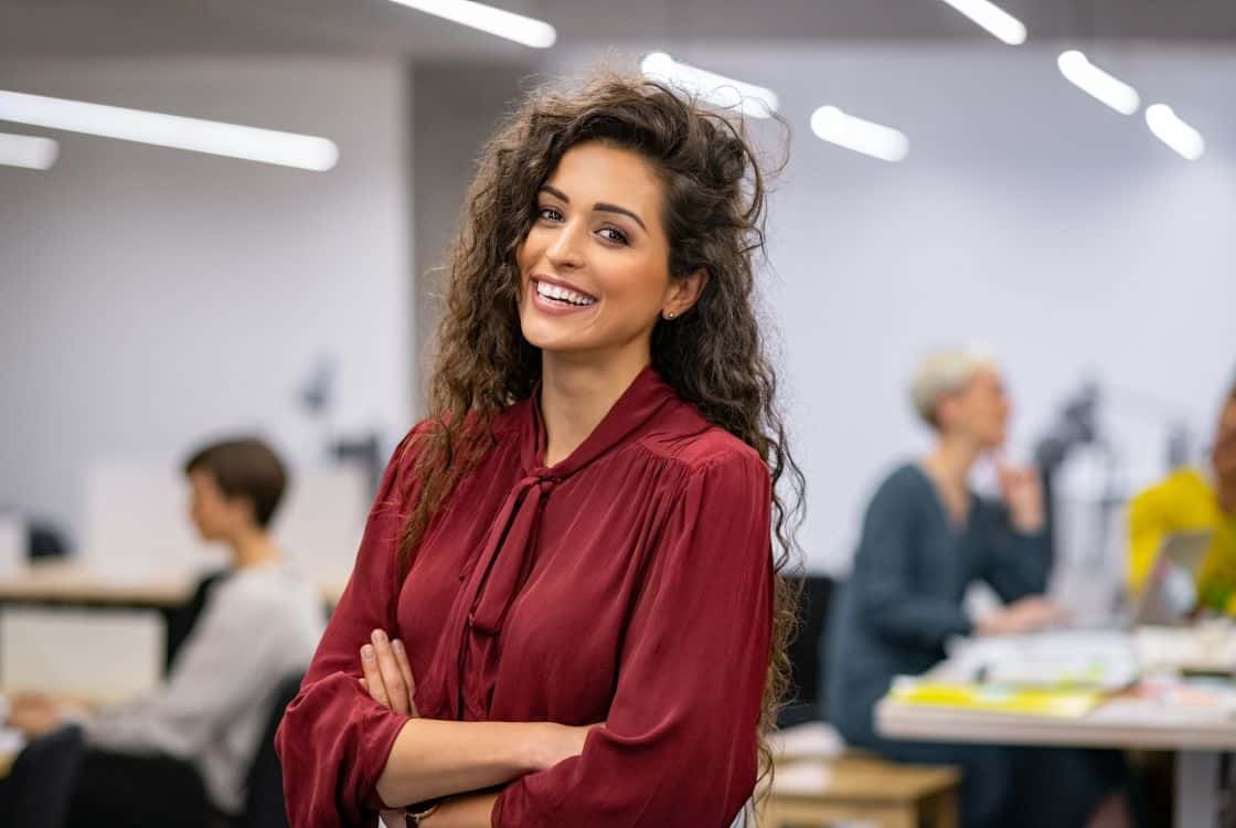 Mujer joven morena sonriente en oficina