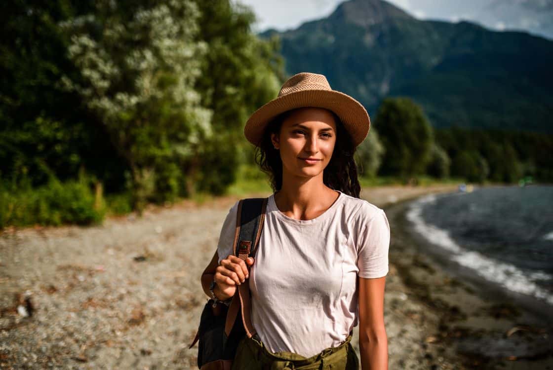 Mujer joven viajando con un sombrero y mochila