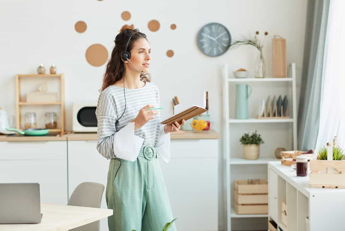 mujer con auriculares en habitación trabajando online